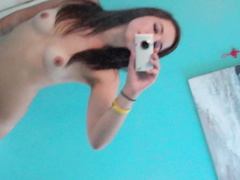 Sexy brunette takes several selfies and fingers  her pussy