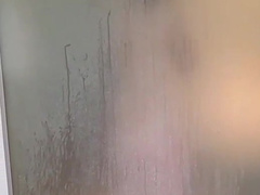 Milf in the shower behind frosted glas