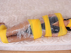 Swimsuit Clad Babe Gia Mancini Is Coiled In Plastic And Bright Yellow Bandages!
