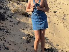Girl pee in jeans skirt on the public beach