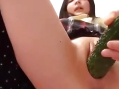 Young Japanese girl plays with a cucumber