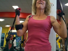 old fit woman exhausts herself training arms in gym